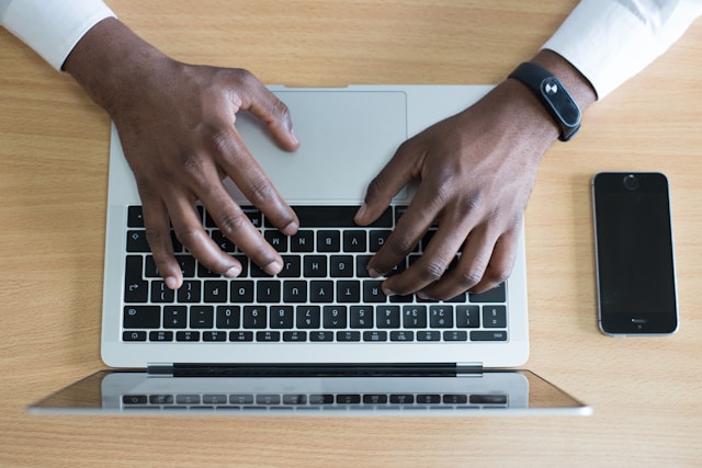 man typing on laptop computer