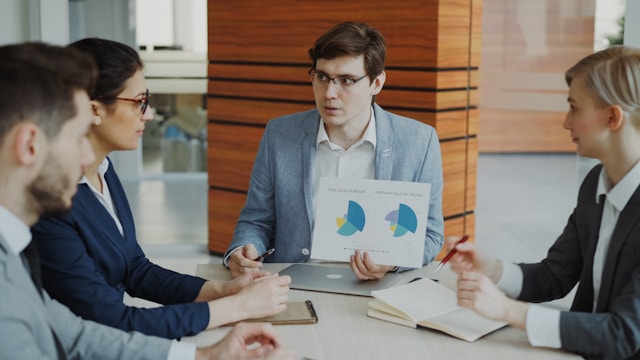 Man presenting charts to colleagues in a meeting