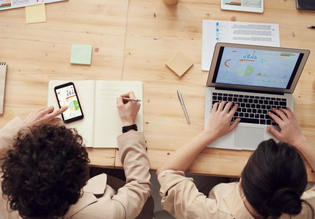 Overhead shot of two colleagues collaborating with devices