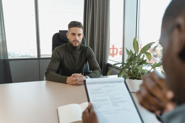 Professional man in turtleneck at office desk