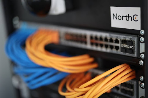 Technician installing fiber optic cables in a server rack