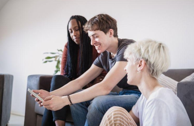 roomates sitting together looking at phone app