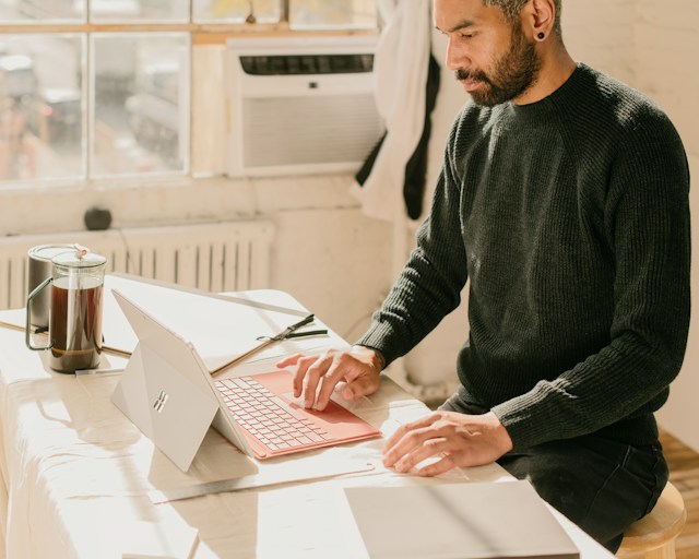 a man sitting at a table using a laptop